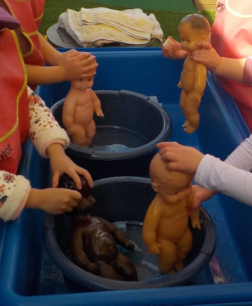 washing dolls for benefits of water play in early childhood