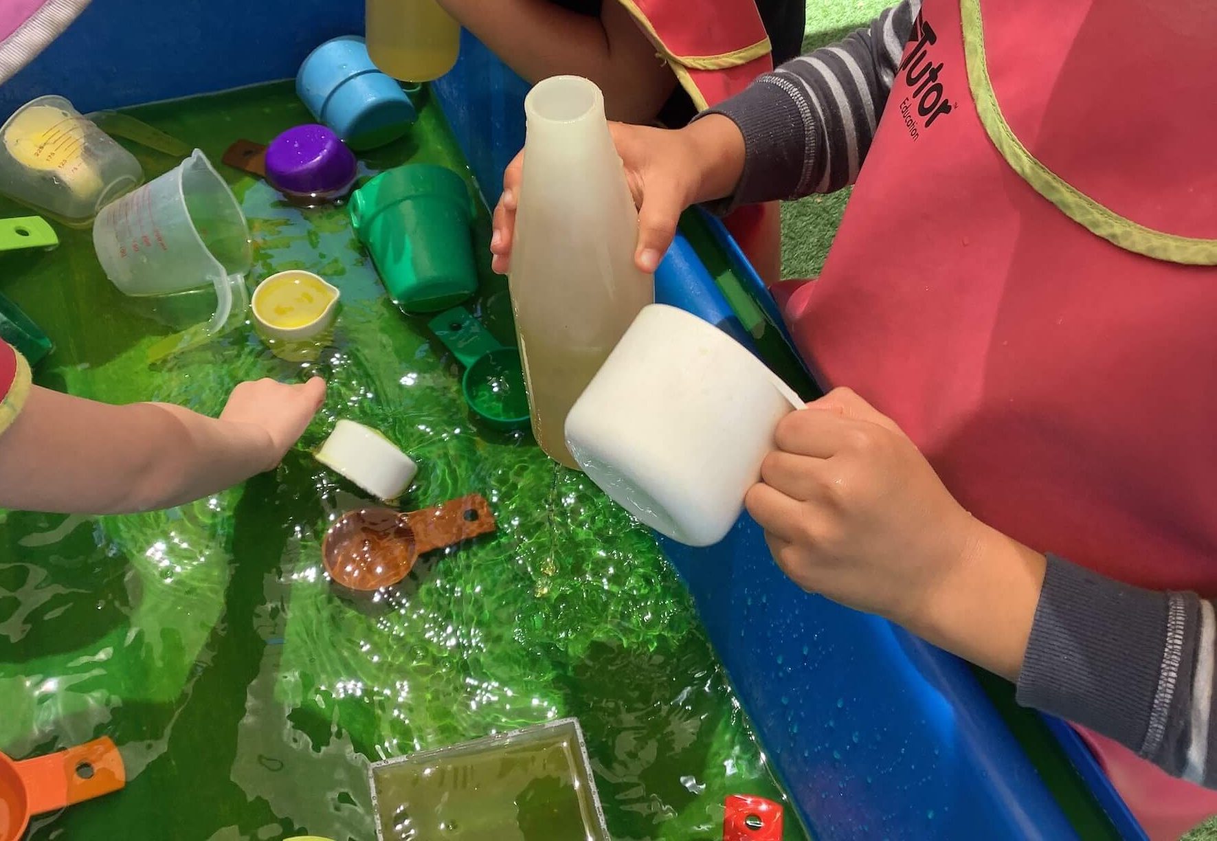 children playing with water for benefits of water play in early childhood