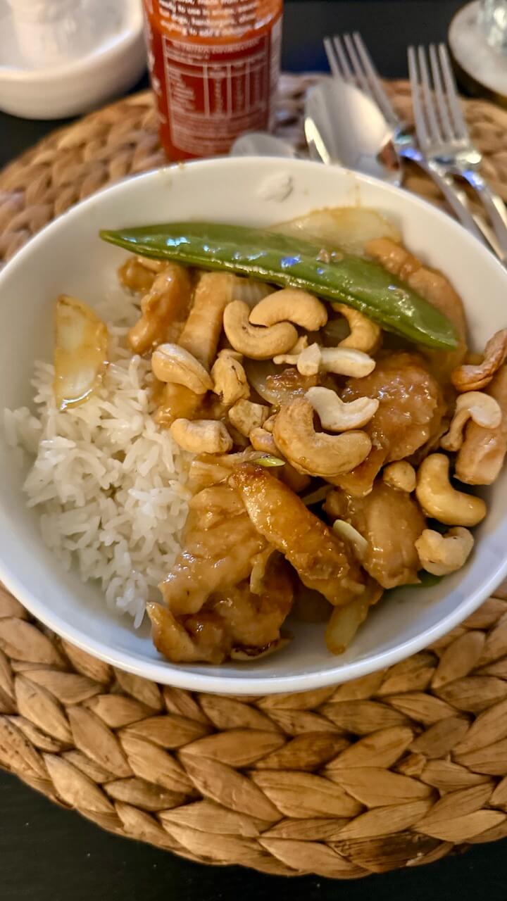 Chicken with cashews and snow peas served with rice
