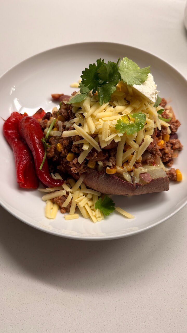 Chilli con carne with purple sweet potato, cheese and sour cream